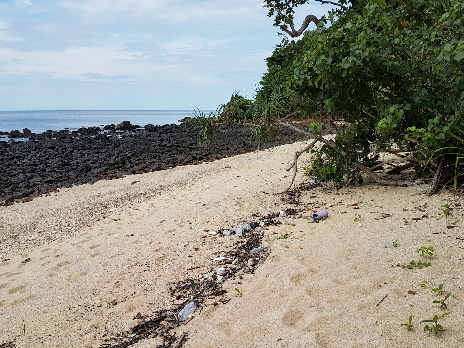 Foto van Ewu Beach met helder zand & rotsen oppervlakte