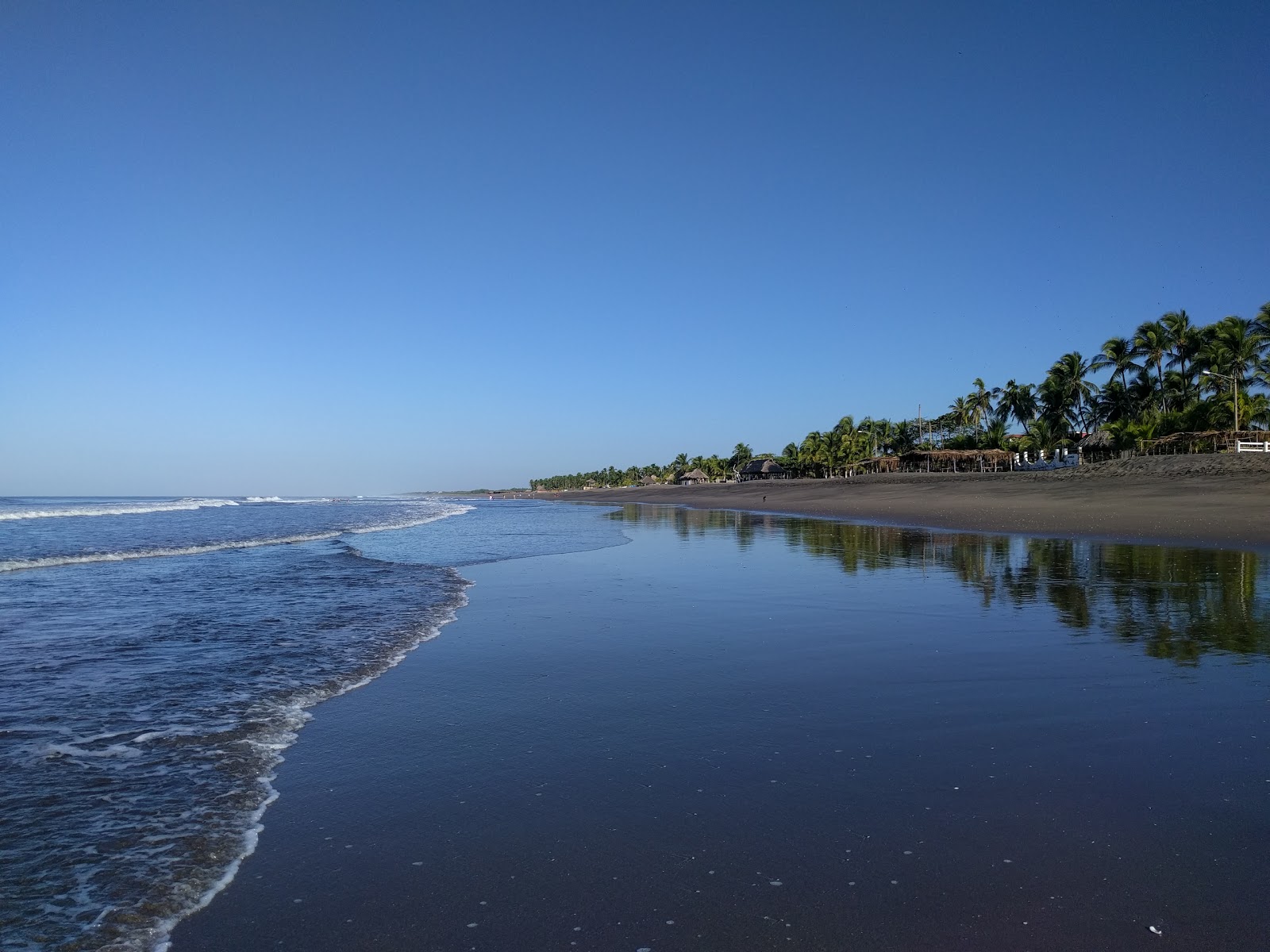Foto de Poneloya beach com linha costeira longa e reta