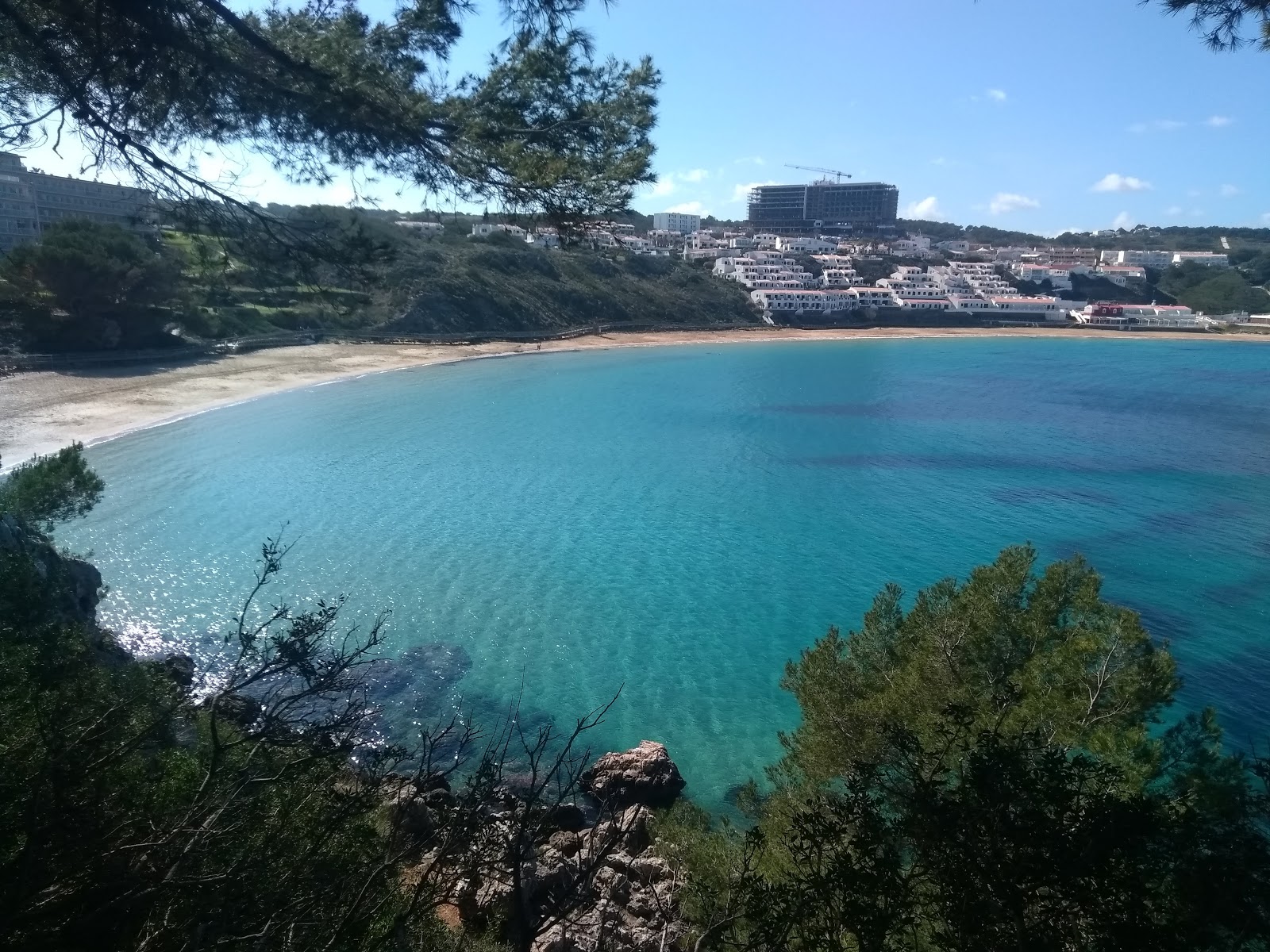 Foto von Arenal d'en Castell Strand und die siedlung