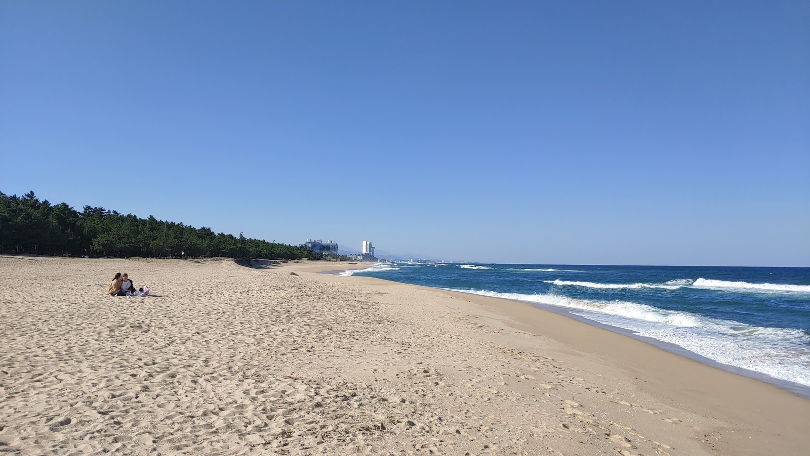Photo de Songjeong Beach avec l'eau cristalline de surface