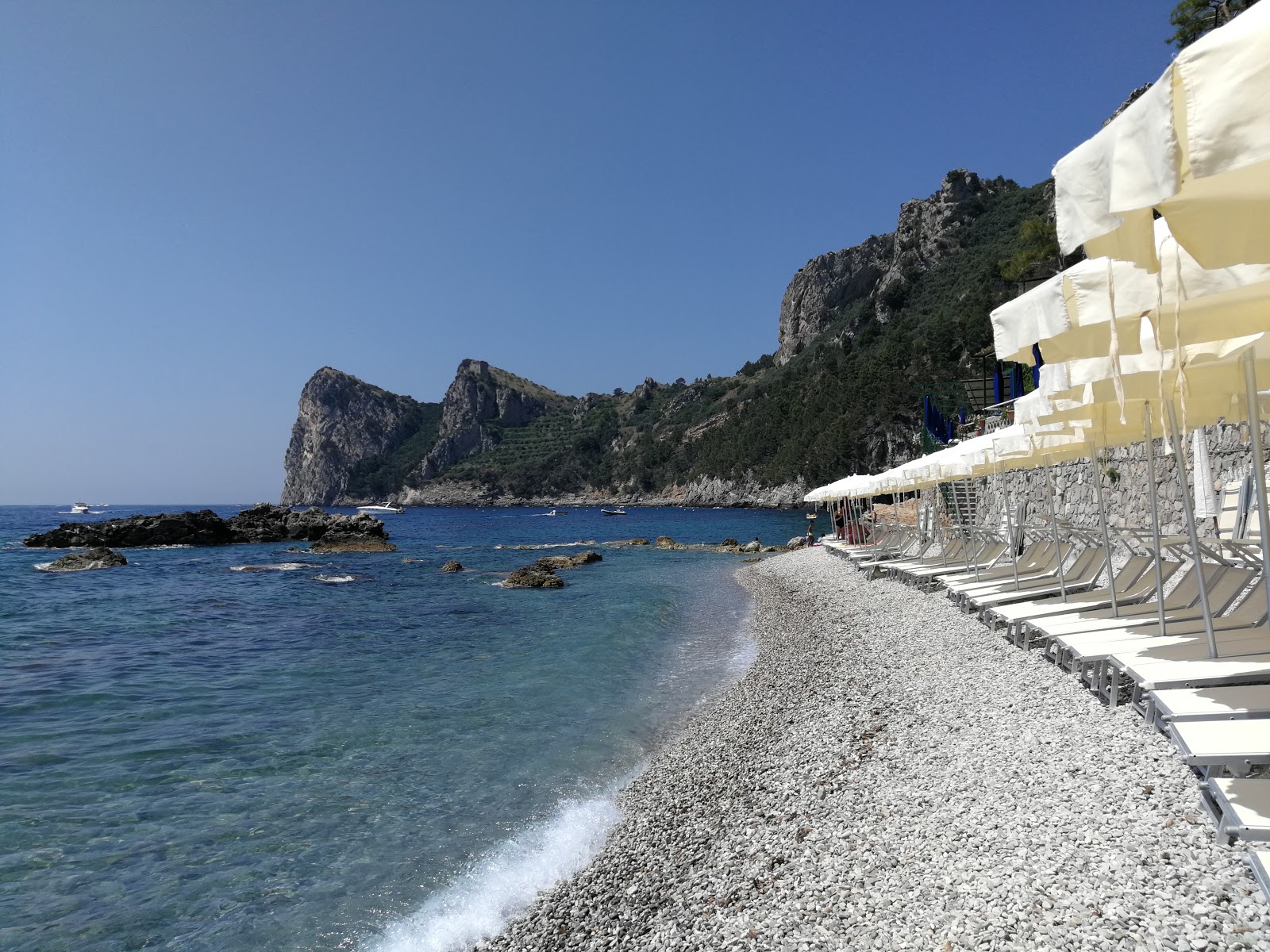 Foto av Spiaggia la Perla med blå rent vatten yta