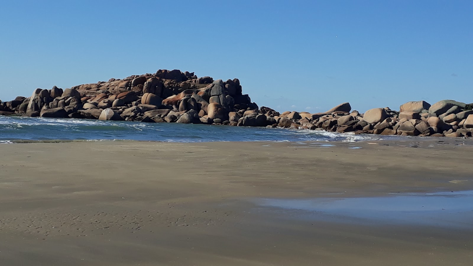 Foto af Praia do Tamborete bakket op af klipperne