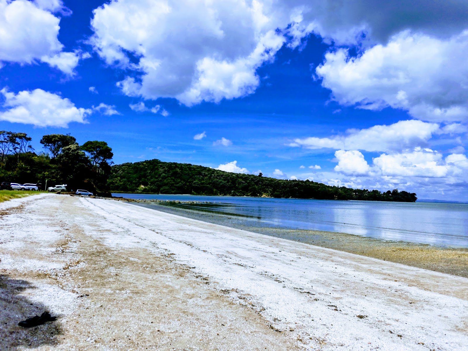 Foto av Sandy Beach med beige sand och småsten yta