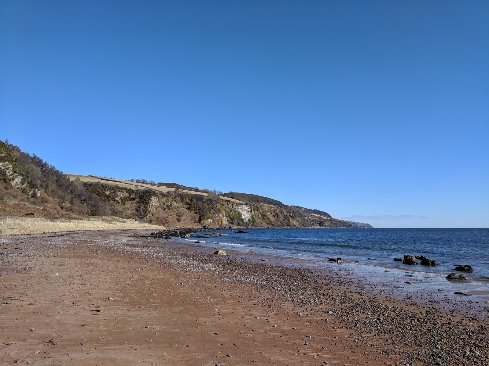 Foto di Rosemarkie Beach Caves con una superficie del sabbia beige e rocce