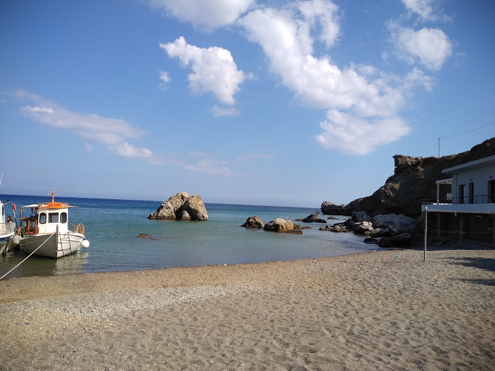 Foto av Maridaki beach omgiven av berg