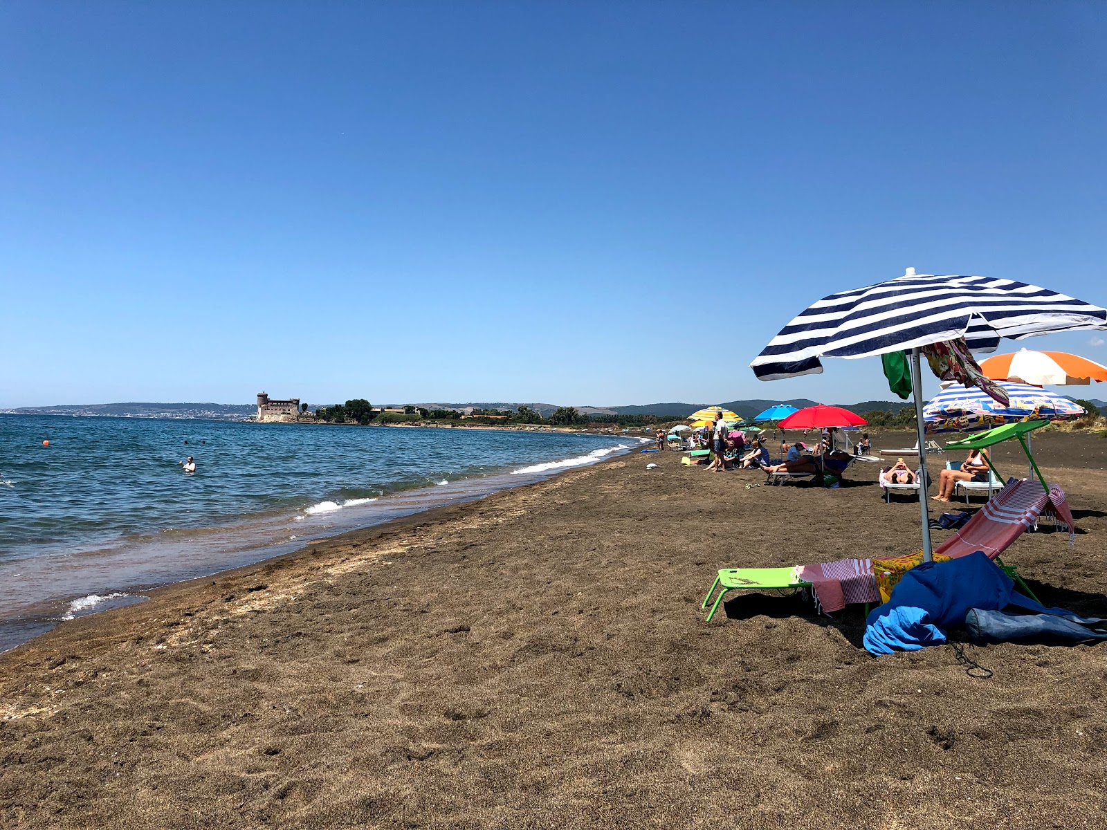 Foto van Sabbie Nere St Severa met blauw water oppervlakte