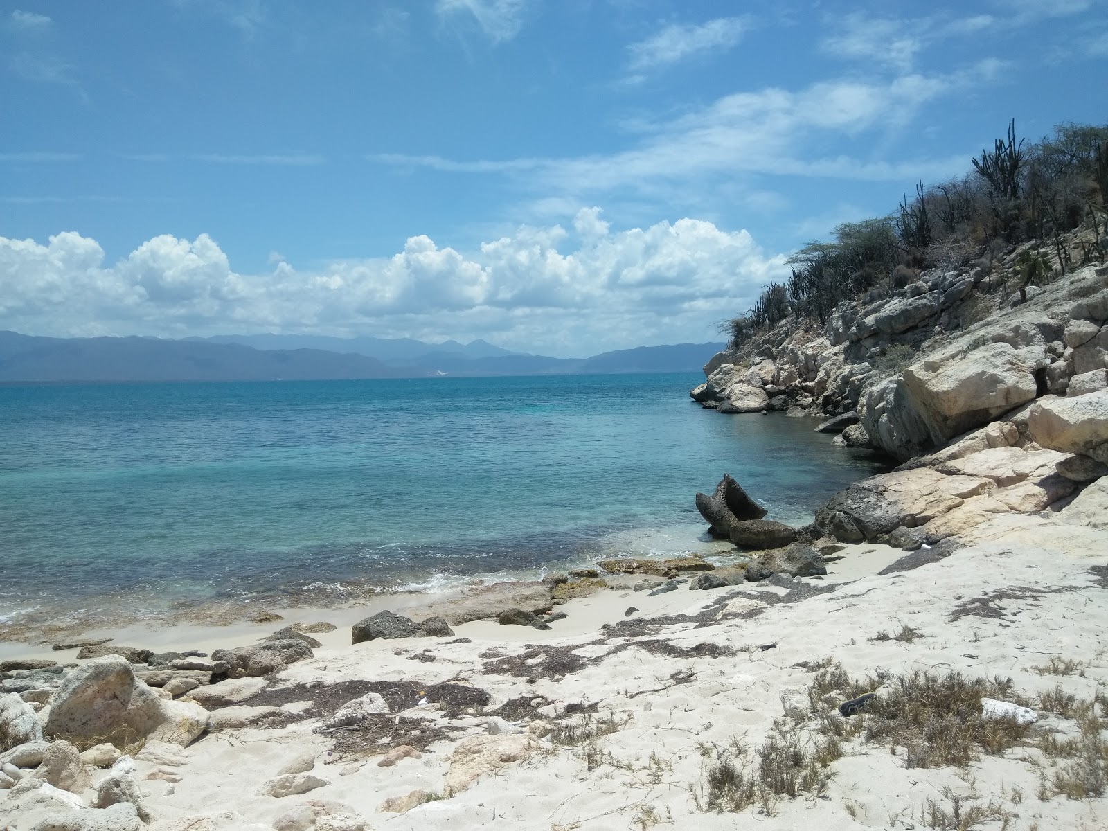 Foto van Pirates Cave beach met beige zand en stenen oppervlakte