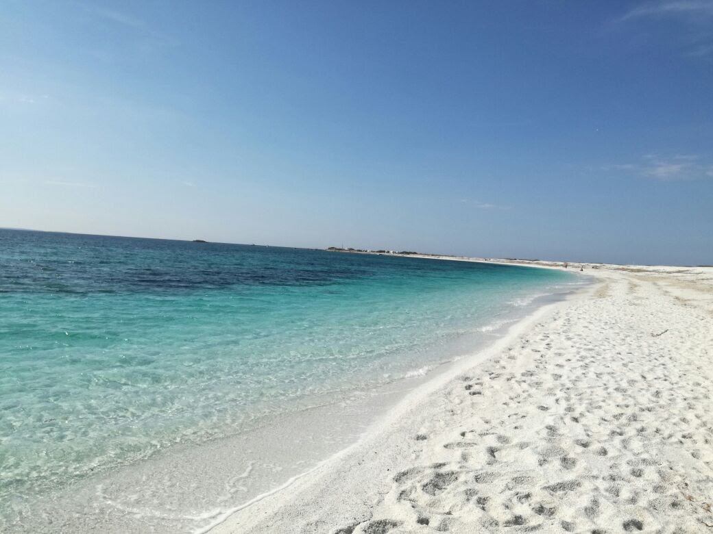 Valokuva Spiaggia di Portu S'Ueddaista. pinnalla kirkas hiekka:n kanssa