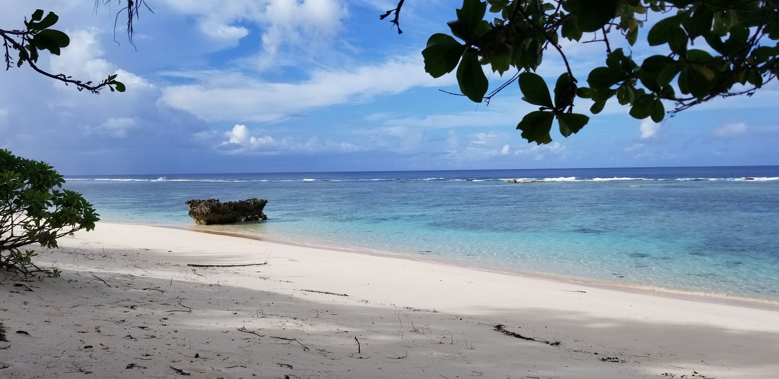 Zdjęcie Jinapsan Beach z powierzchnią jasny piasek