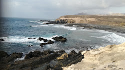 Foto av Playa de Ugan omgiven av berg