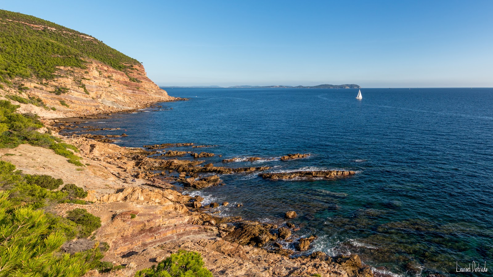 Foto von Plage du Bau Rouge umgeben von Bergen