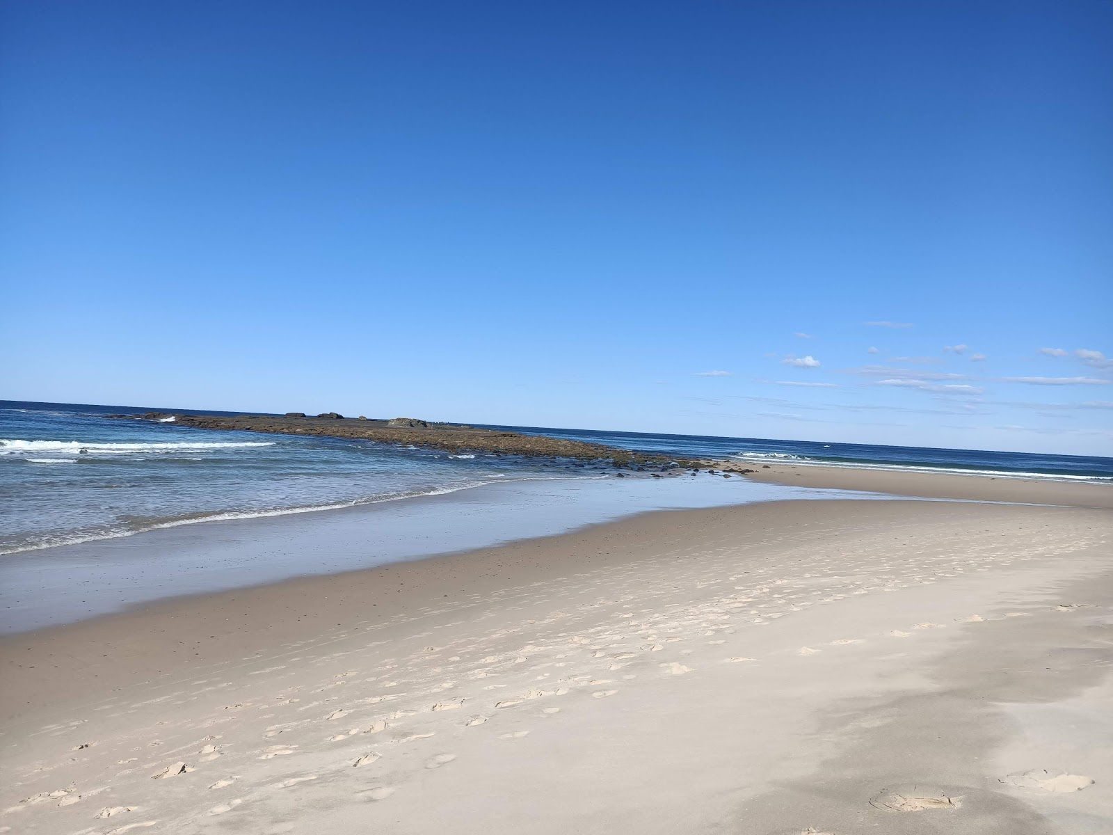 Fotografie cu Island Beach cu o suprafață de apă pură albastră
