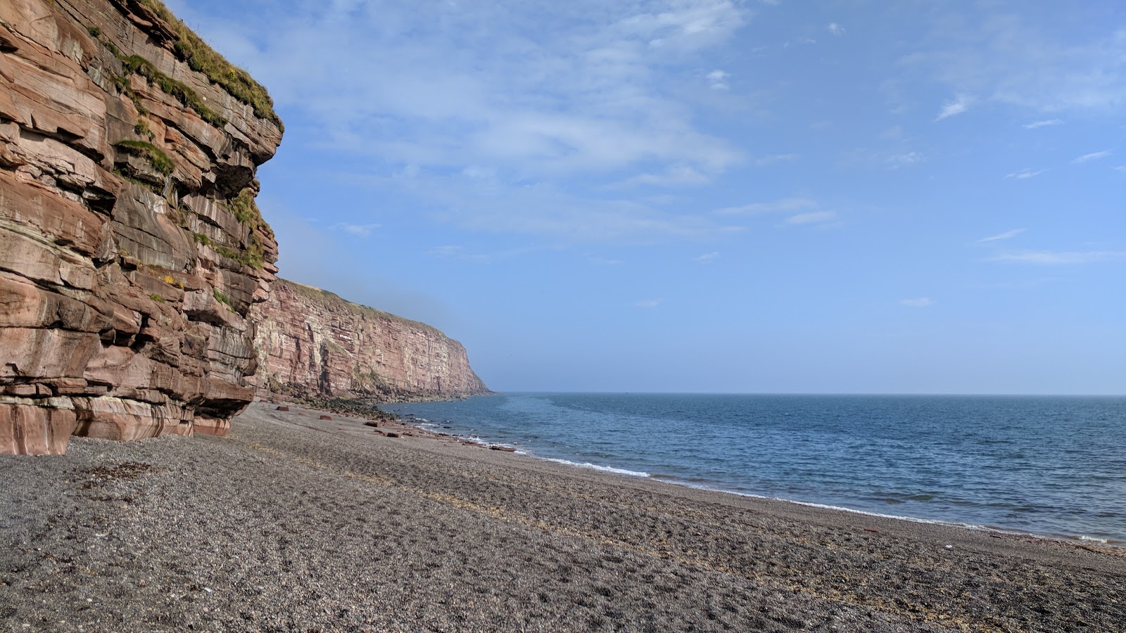 Fleswick Bay Beach'in fotoğrafı geniş bir kıyı şeridi ile birlikte