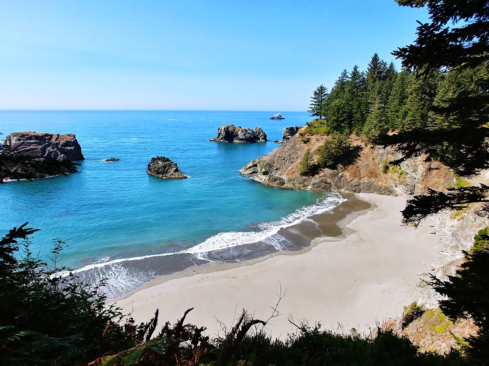 Valokuva Secret Beach Oregonista. pinnalla harmaa hiekka:n kanssa