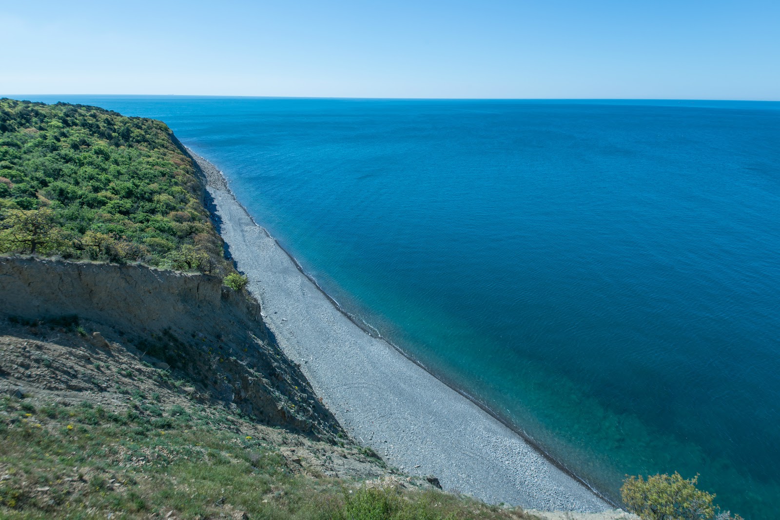Foto af Plyazh Utrish bakket op af klipperne