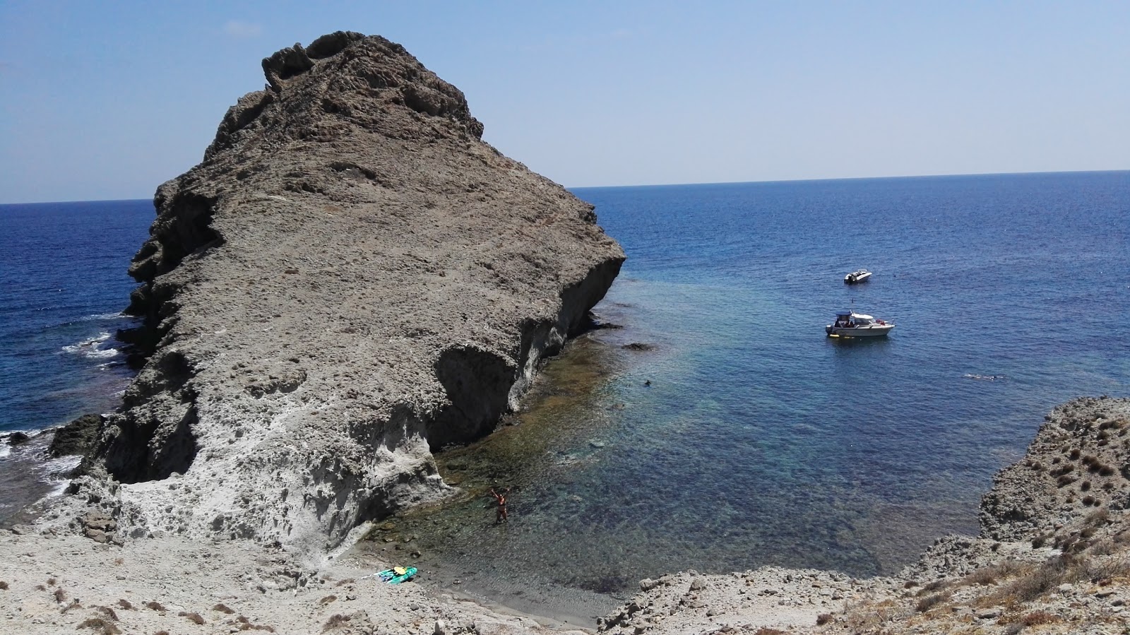 Foto di Cala de las Hermanicas con una superficie del sabbia grigia e rocce