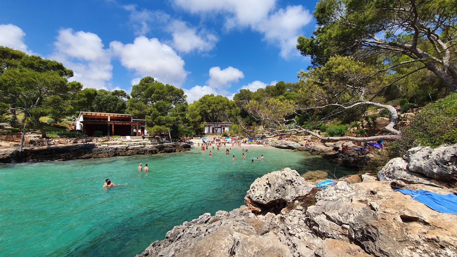 Foto av Cala Mitjana med fin beige sand yta
