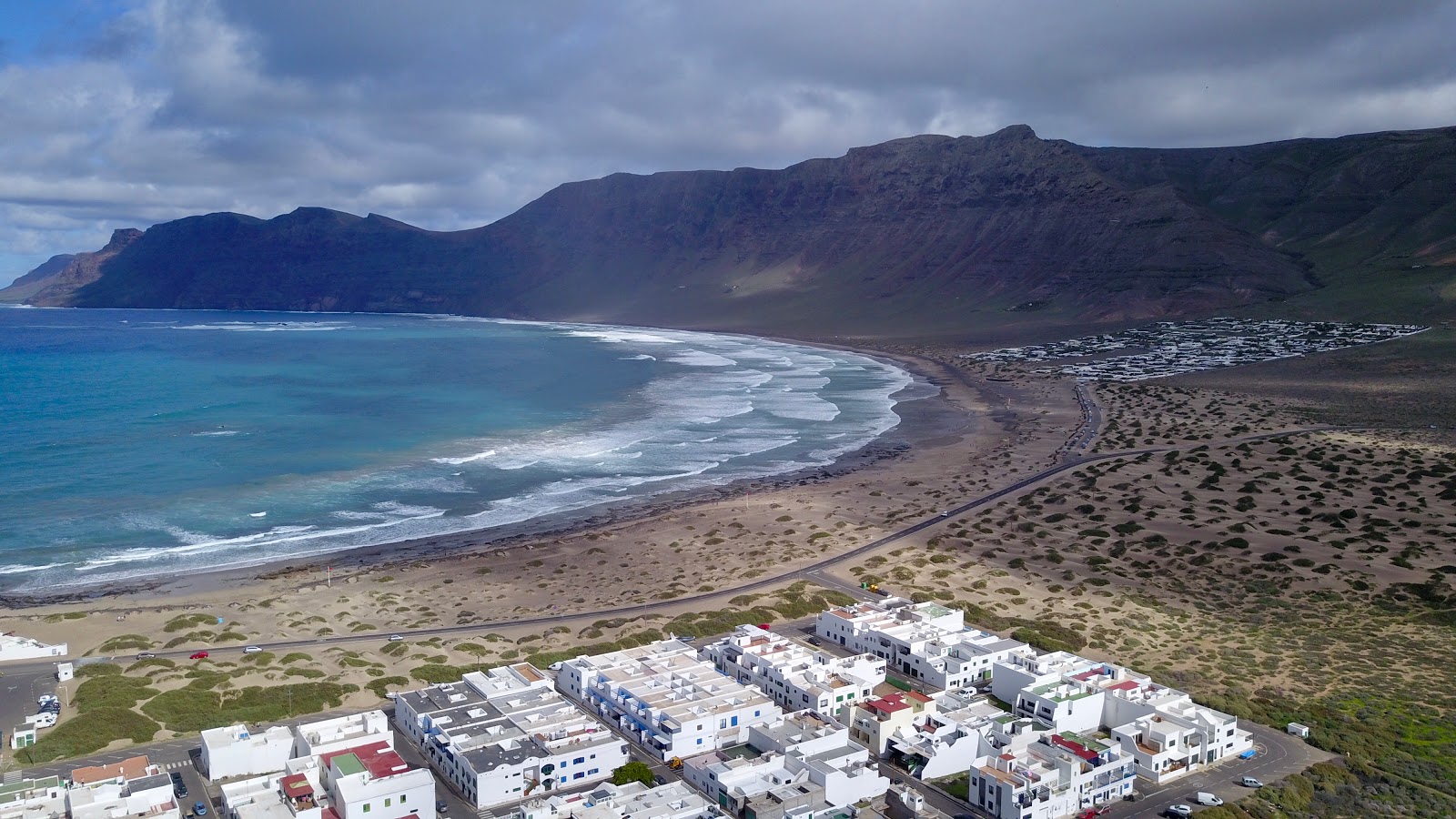 Foto van Famara Strand met licht groen water oppervlakte