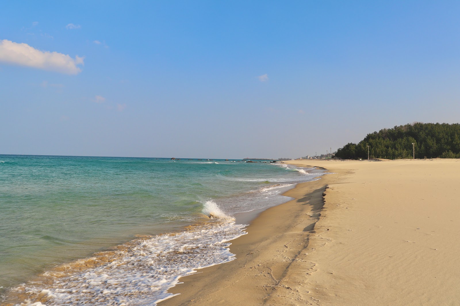 Fotografie cu Mangsang Beach cu o suprafață de apa pură turcoaz