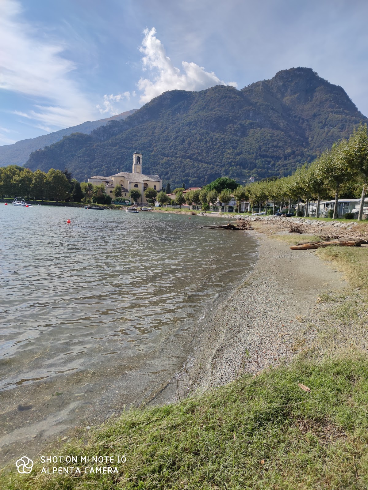 Valokuva Lido di Dongo Beachista. tukeutunut kallioilla