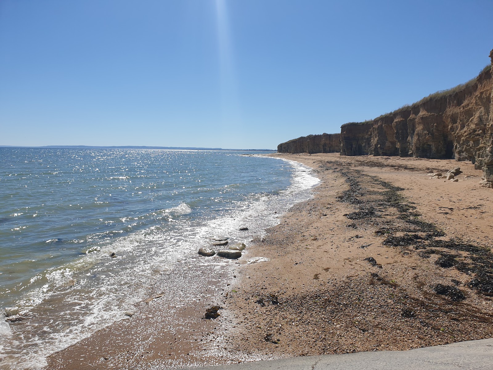 Fotografie cu Plaja Sword cu o suprafață de nisip ușor și pietricel