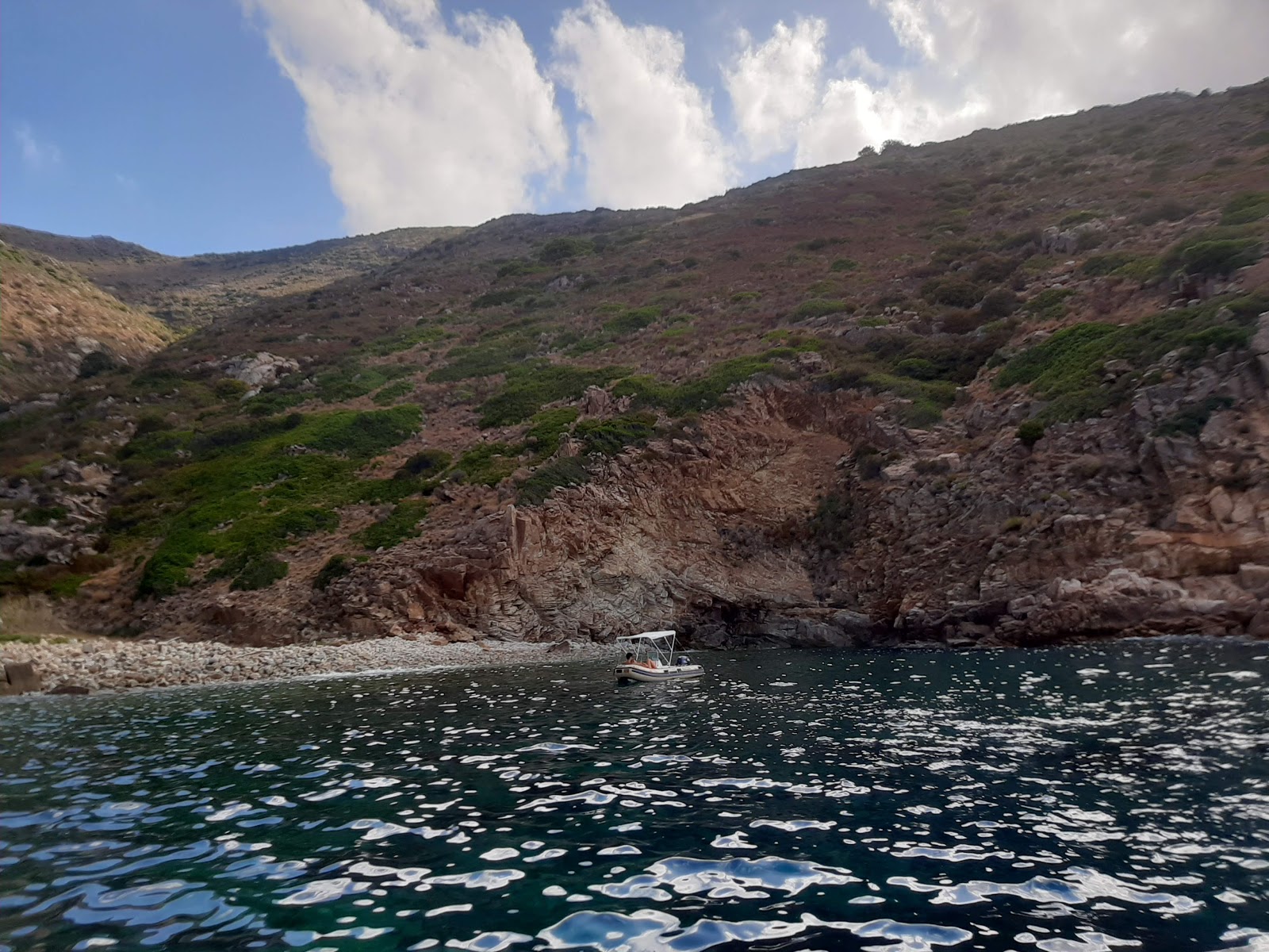 Cala del Corvo'in fotoğrafı mavi saf su yüzey ile