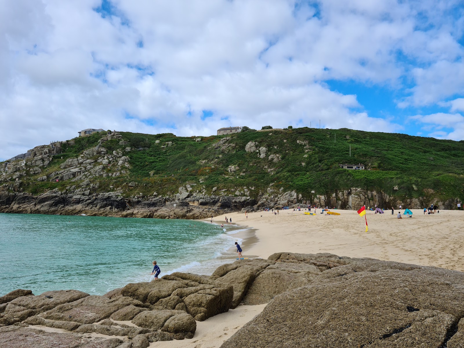 Foto av Porthcurno Beach omgiven av berg