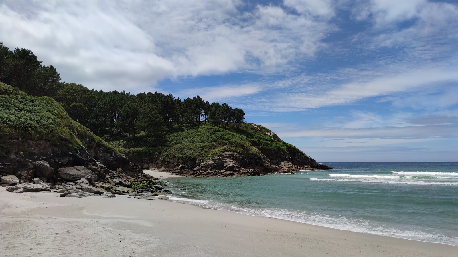 Praia de Porrido'in fotoğrafı mavi saf su yüzey ile