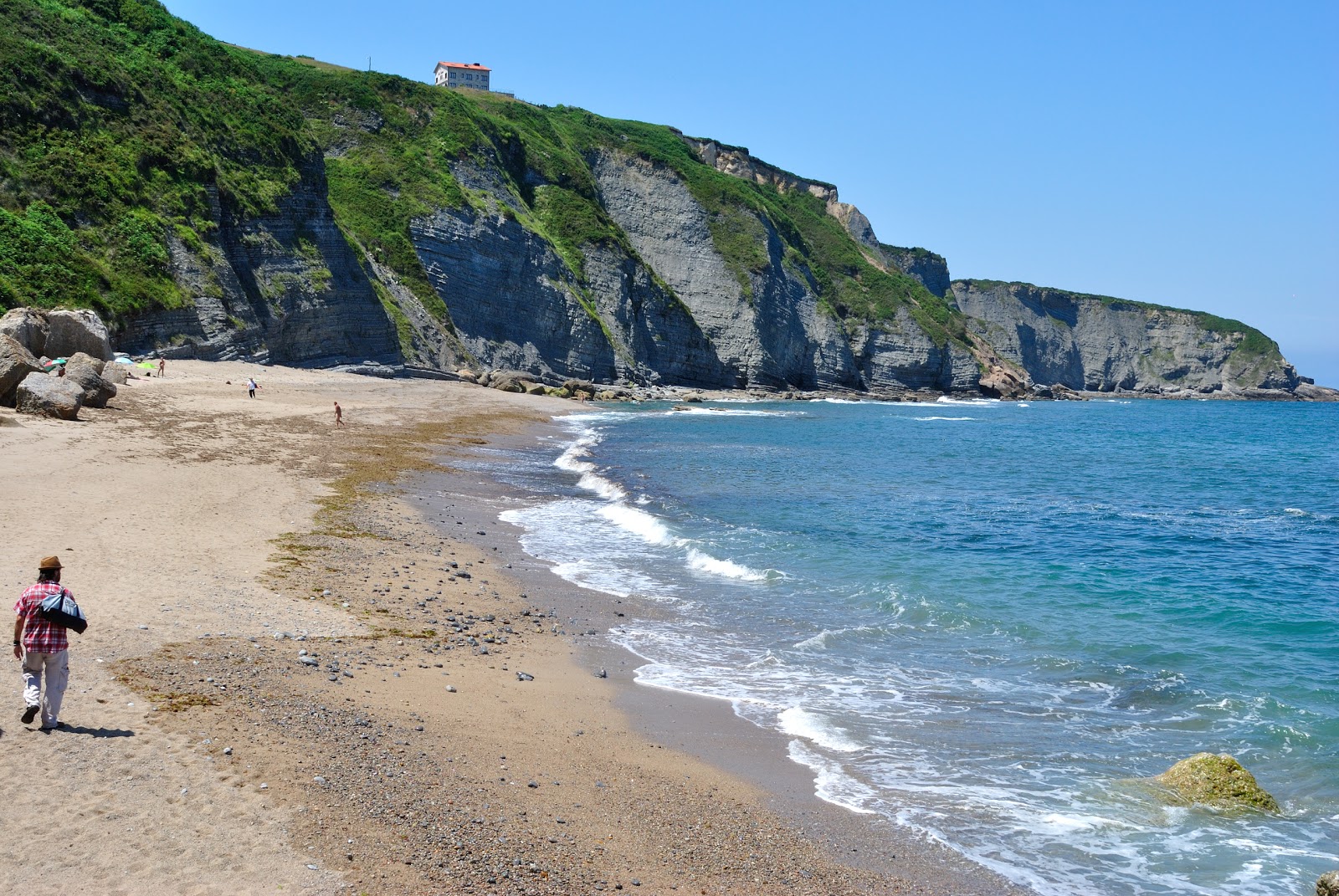 Fotografie cu Playa de Serin cu o suprafață de nisip gri și pietricel