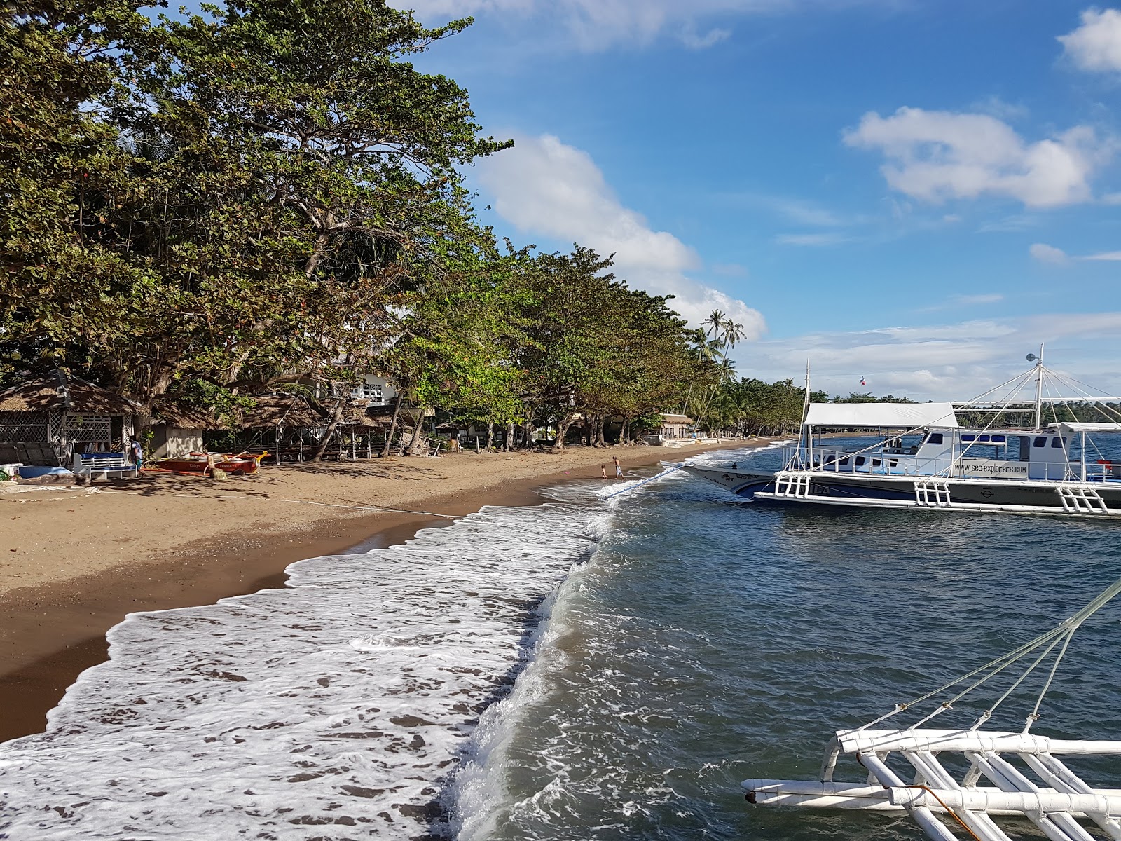 Poblacion Beach'in fotoğrafı geniş bir kıyı şeridi ile birlikte