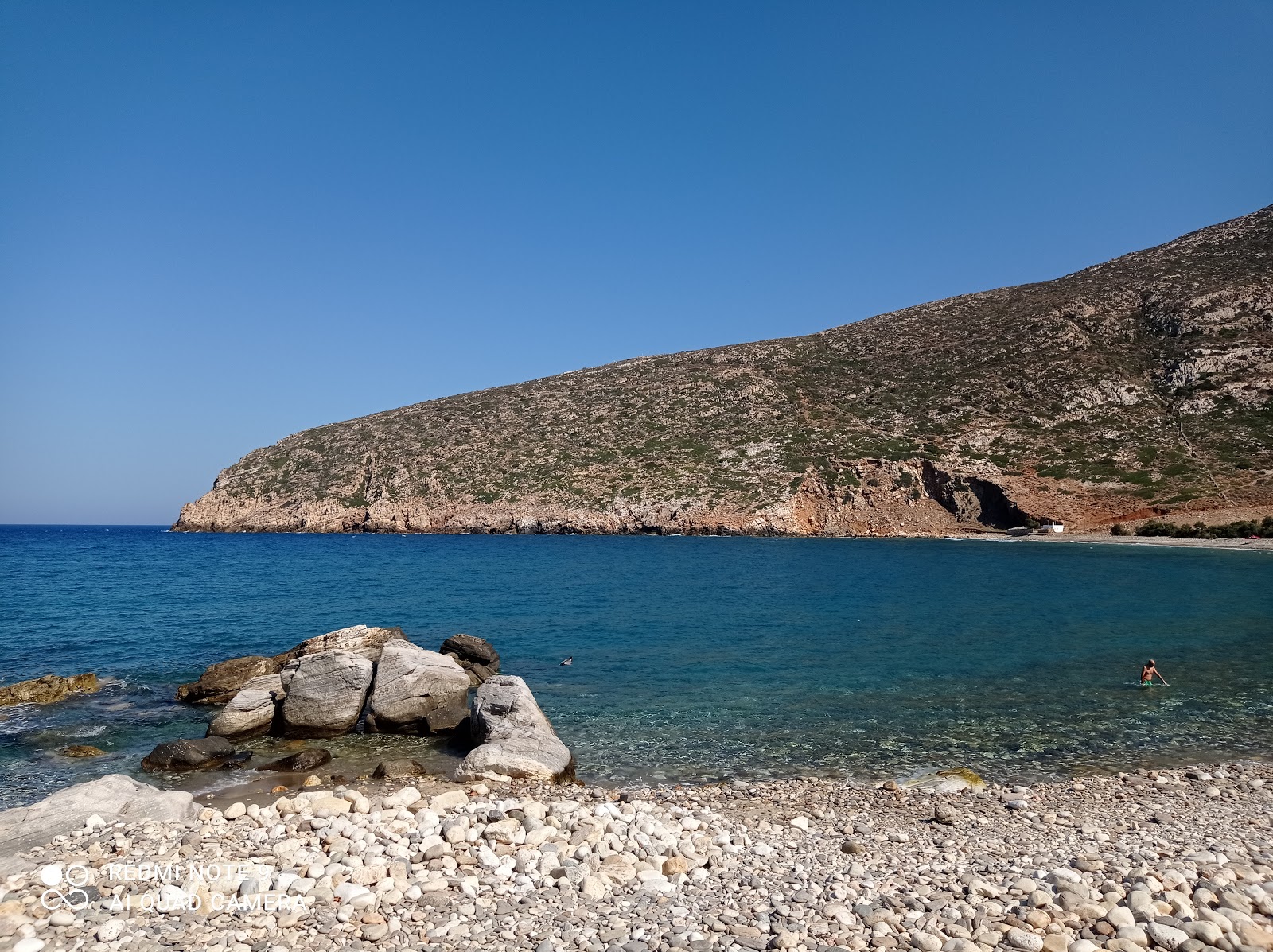 Apollonas beach'in fotoğrafı turkuaz saf su yüzey ile