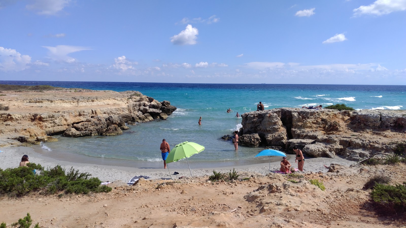 Conca Specchiulla beach'in fotoğrafı mavi saf su yüzey ile