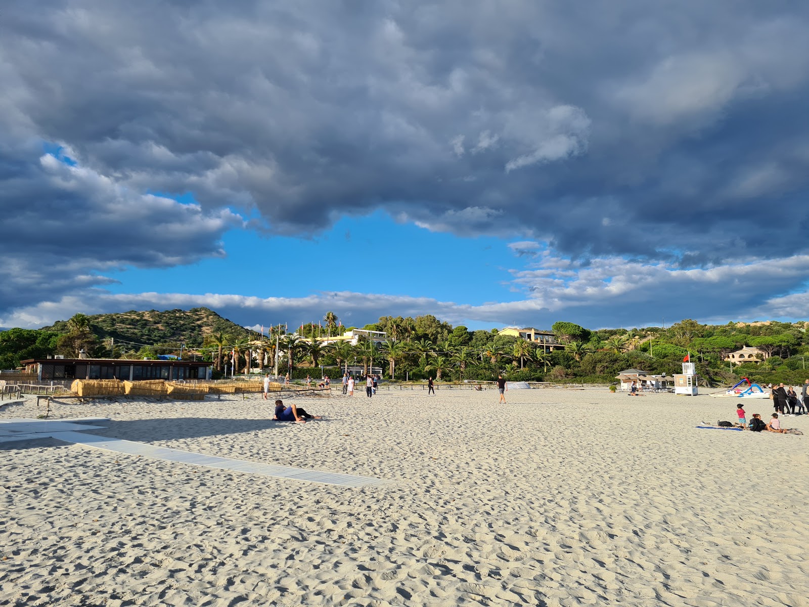 Foto av Spiaggia di Simius omgiven av klippor