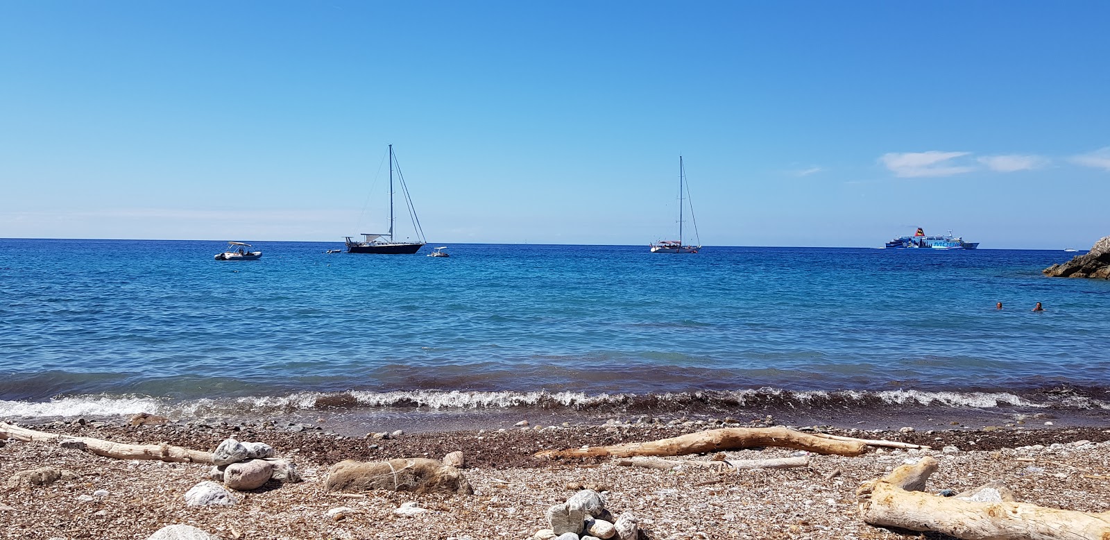 Foto av Cala Mandriola med blå rent vatten yta