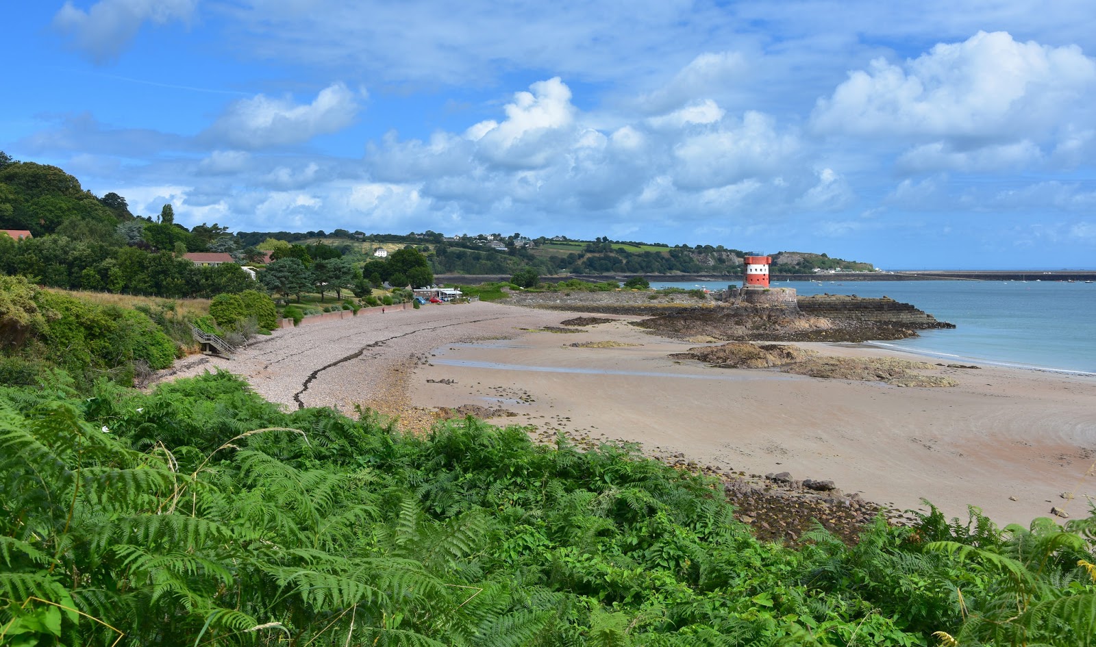 Photo of Archirondel Beach with brown pebble surface