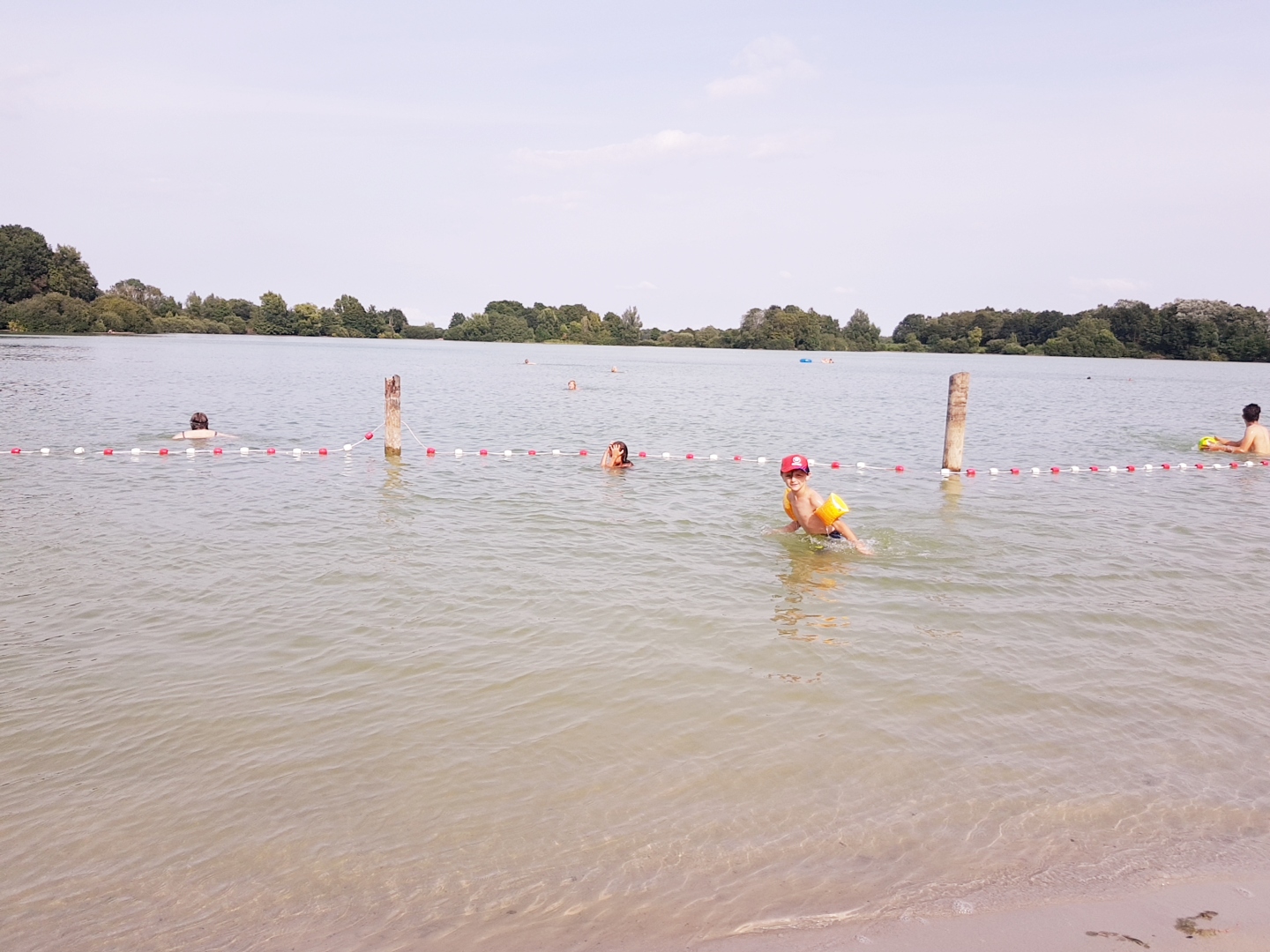 Foto di Kleiner Bornhorster See Strand con una superficie del sabbia beige