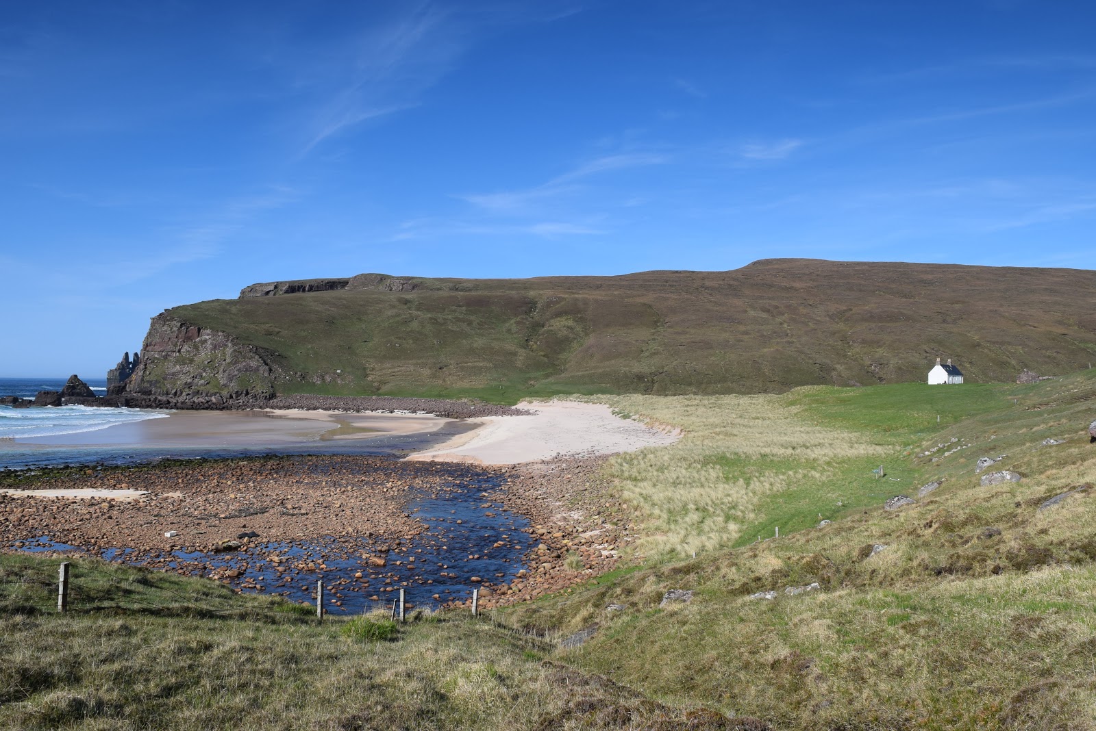 Foto van Kearvaig Bothy met helder zand oppervlakte