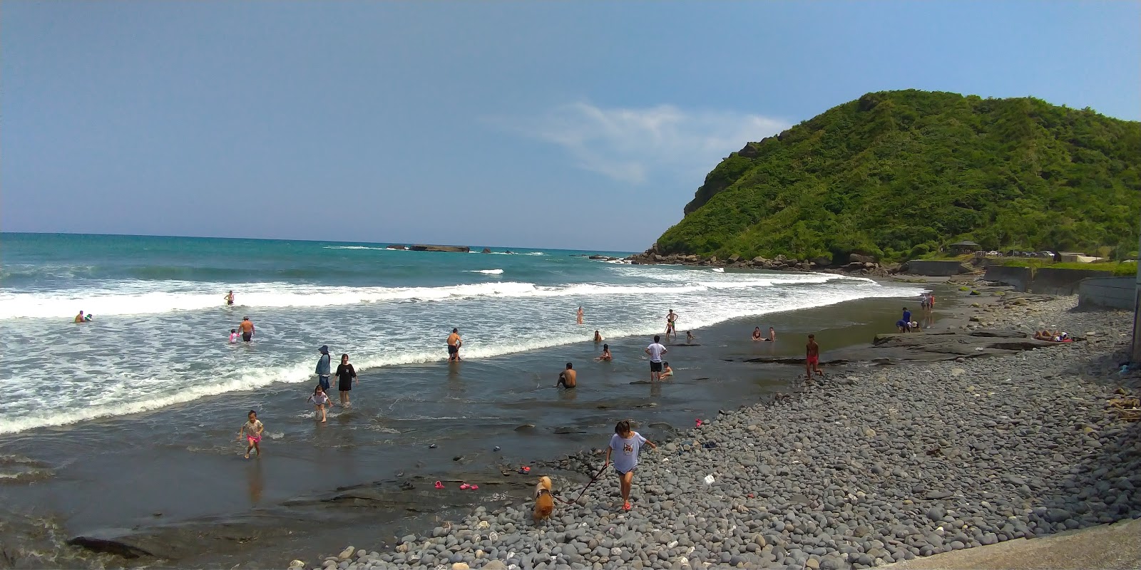 Foto av Jiqi Beach med grå sand och småstenar yta