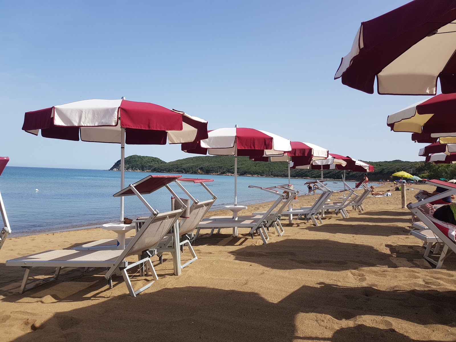 Foto av Baratti stranden omgiven av berg