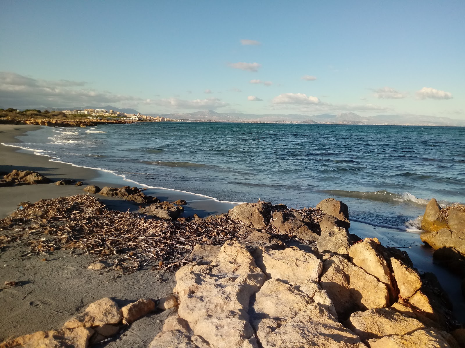 Foto van Cala Punta larga met bruin zand oppervlakte