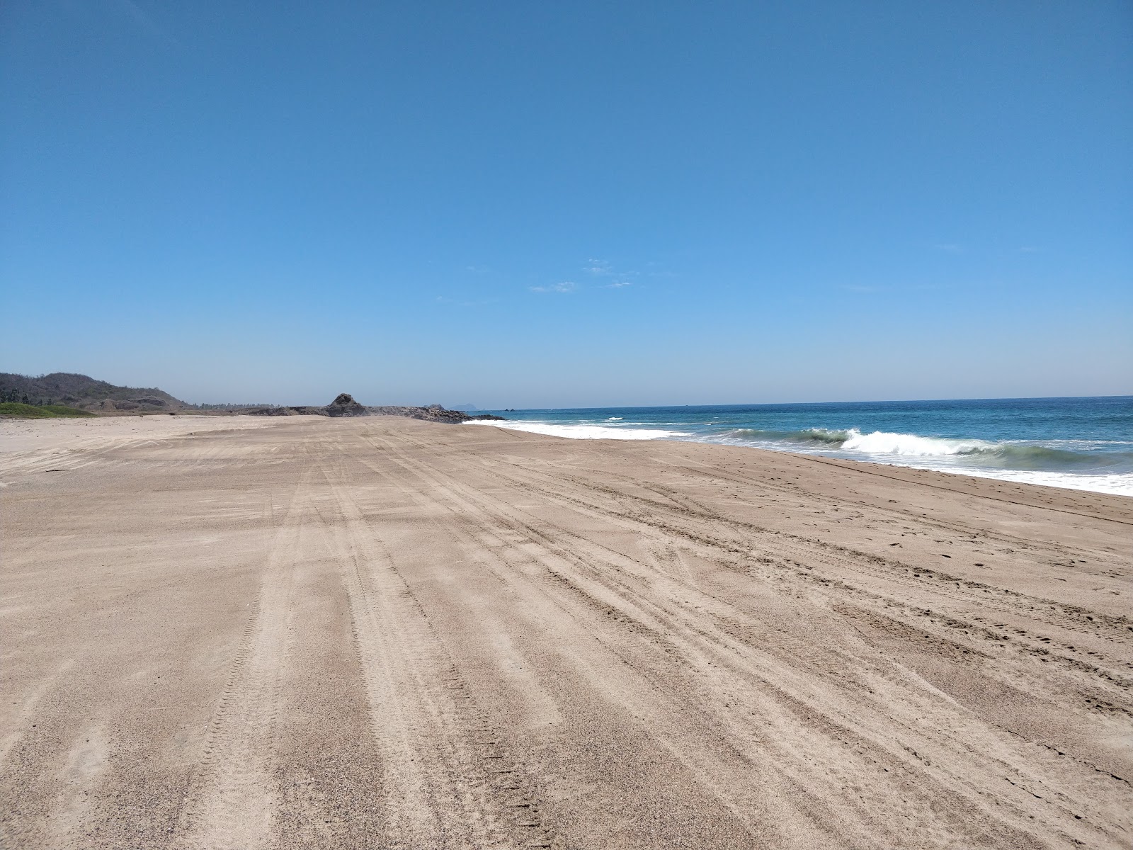 Valokuva Tecuan beachista. pinnalla turkoosi puhdas vesi:n kanssa