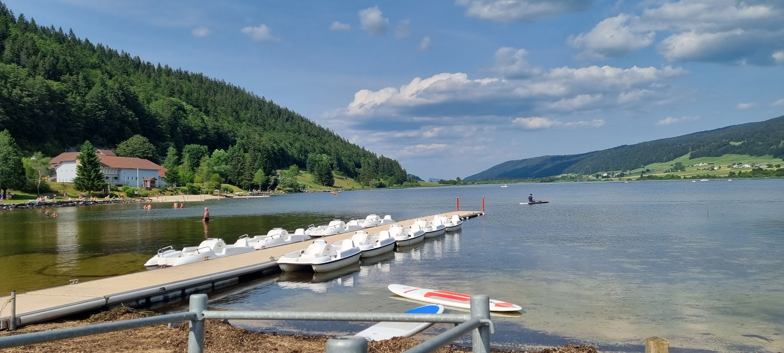 Plage du Lac des Rousses'in fotoğrafı uçurumlarla desteklenmiş