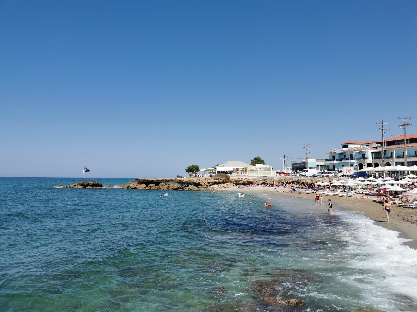 Valokuva Beach Gouvesista. pinnalla ruskea hiekka:n kanssa