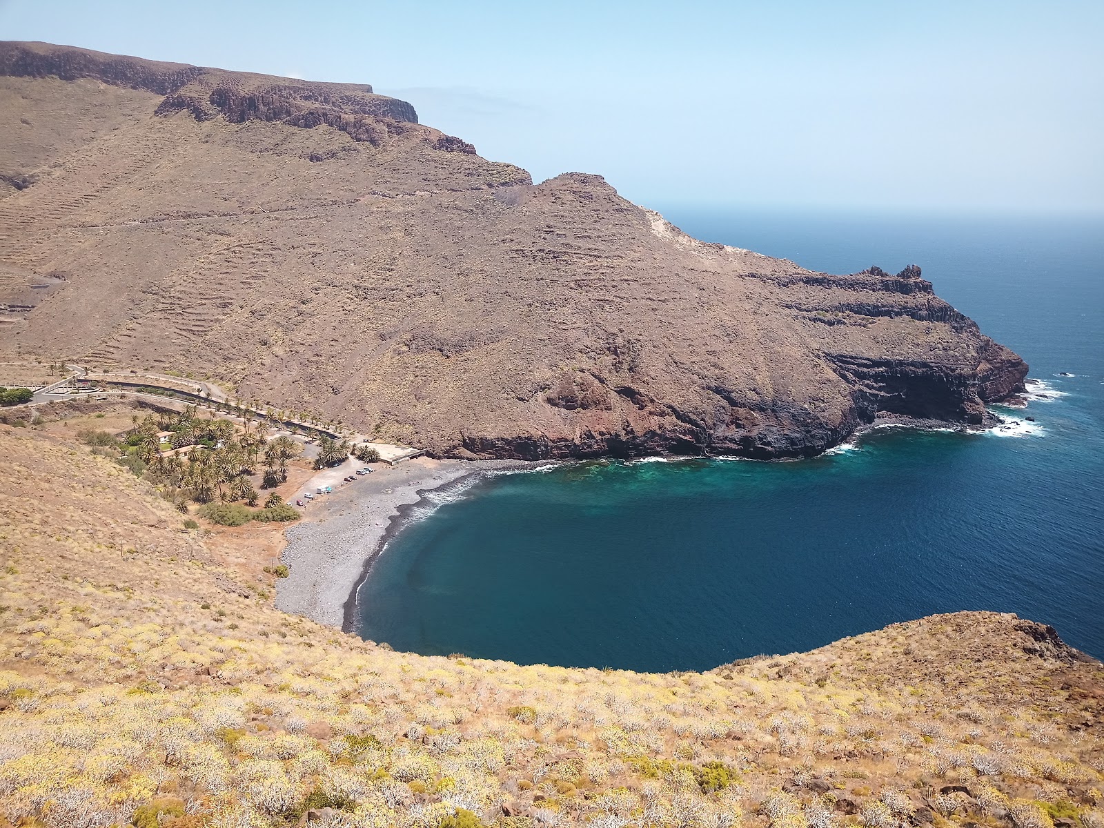 Photo of Playa de Avalo with gray sand &  rocks surface