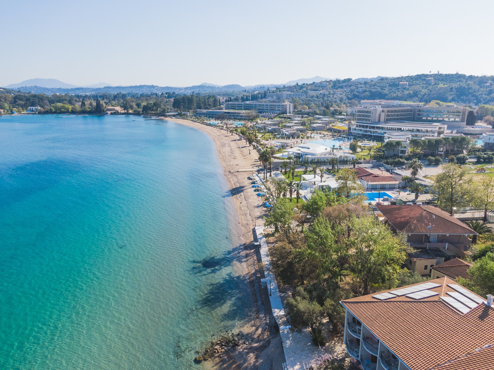Foto de Praia de Dassia com areia bege e seixos superfície
