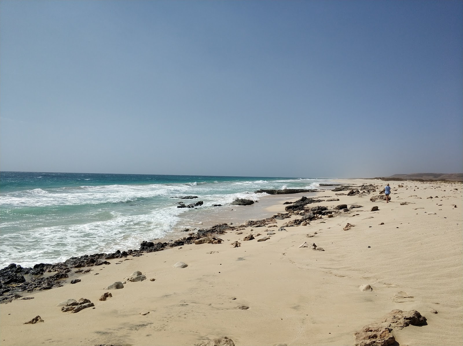 Foto van Joao Barrosa Beach met helder zand & rotsen oppervlakte
