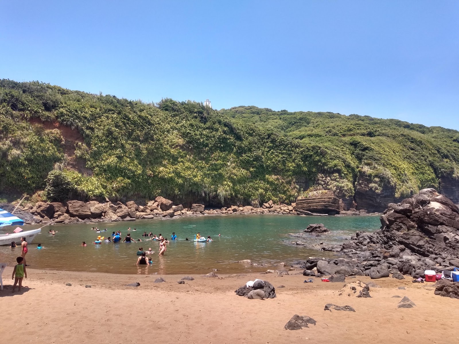 Foto de Playa Escondida con arena beige y rocas superficie