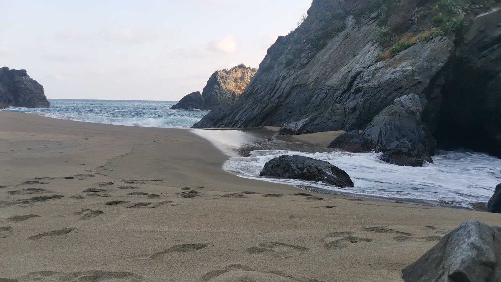 Foto de Playa Cocos com areia fina e marrom superfície