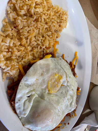 Red chilaquiles with two eggs over easy and rice