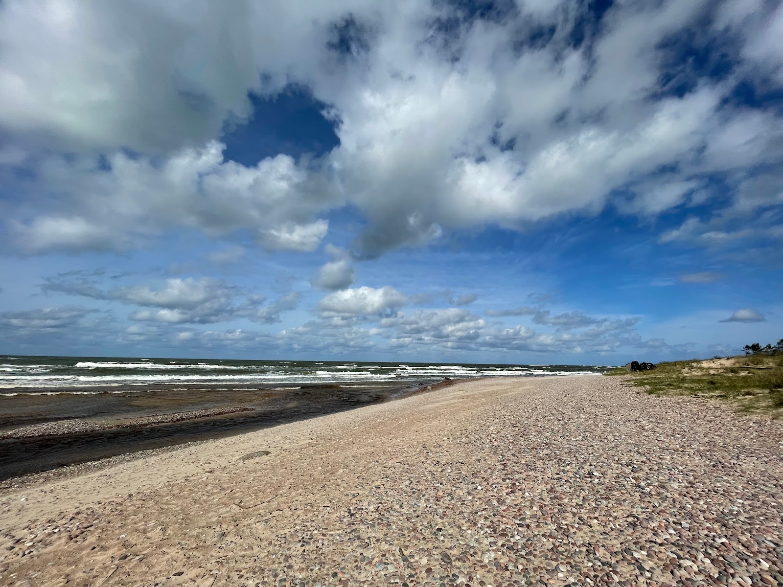 Uzavas upes beach的照片 带有轻质沙和卵石表面